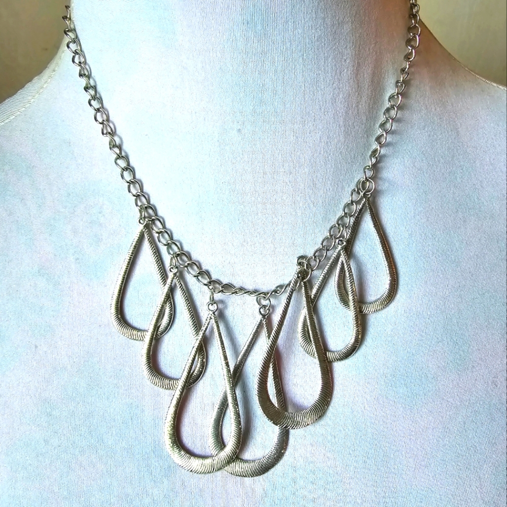 Necklace with multiple teardrop shaped pendants textured silver tone